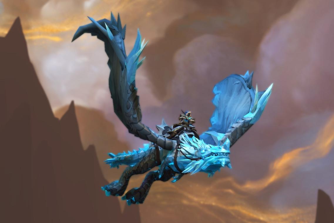 AGainst a turbulent orange-brown and grey sky and silhouetted jagged mountain peaks flies the Spawn of Vyranoth mount - an frosty blue and grey proto-drake inspired by the Dragonflight character Vyranoth.
